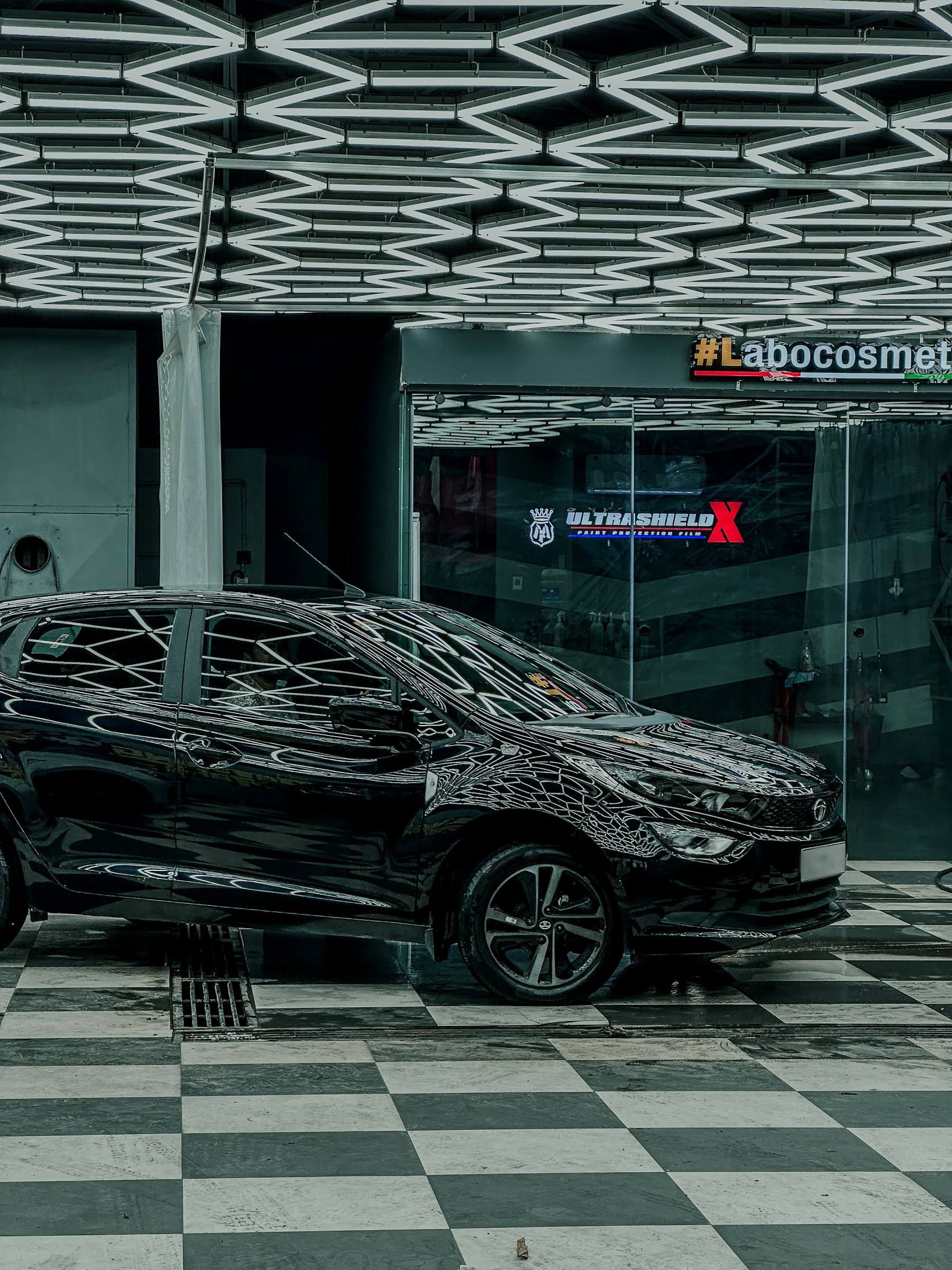 Black vehicle inside a modern detailing studio